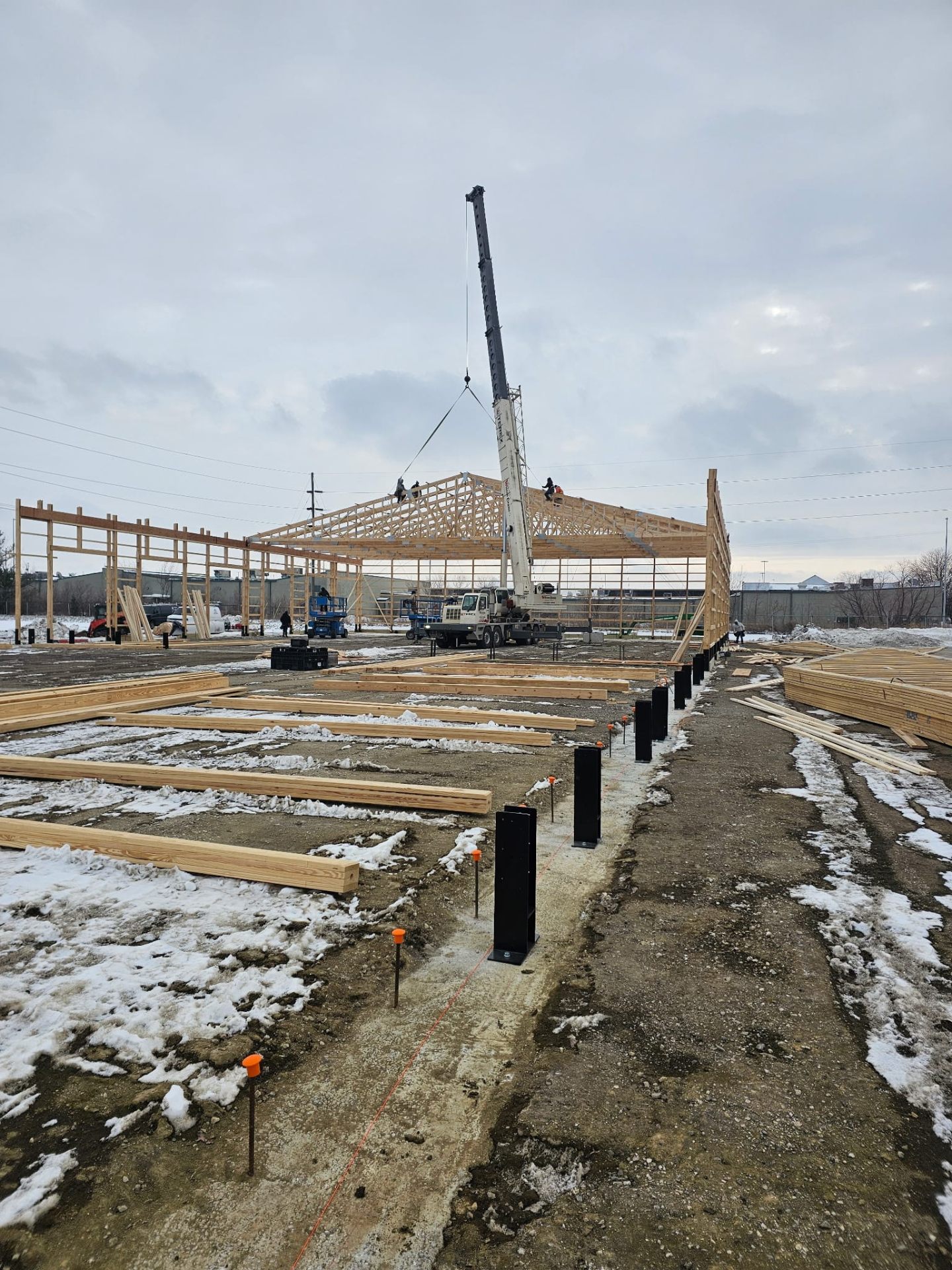 JRH Framing crew with crane setting trusses on a commercial jobsite